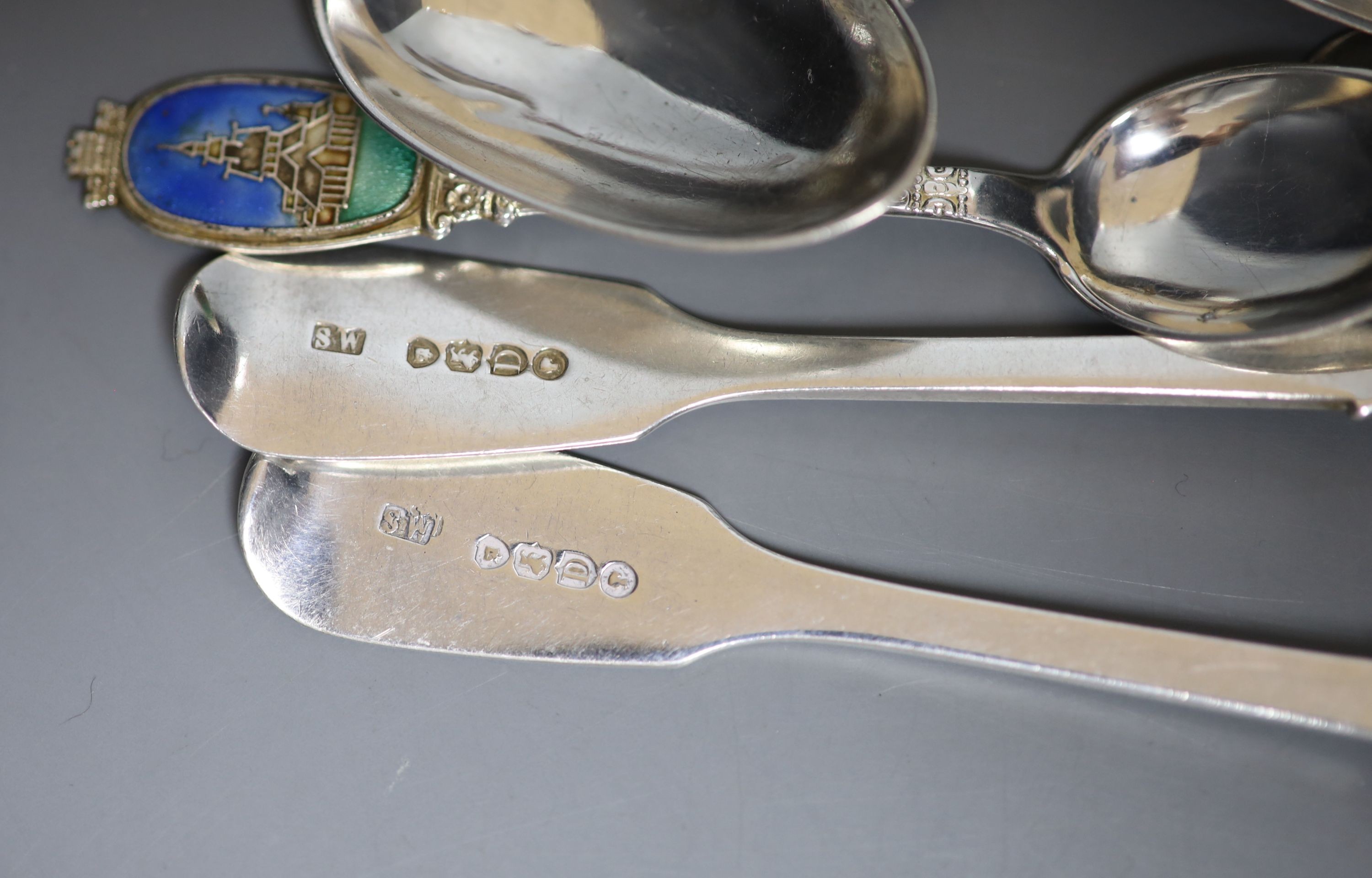 A mixed collection of assorted mainly silver and white metal tea and souvenir spoons, a Georgian silver caddy spoons and two forks, gross 27.5oz.